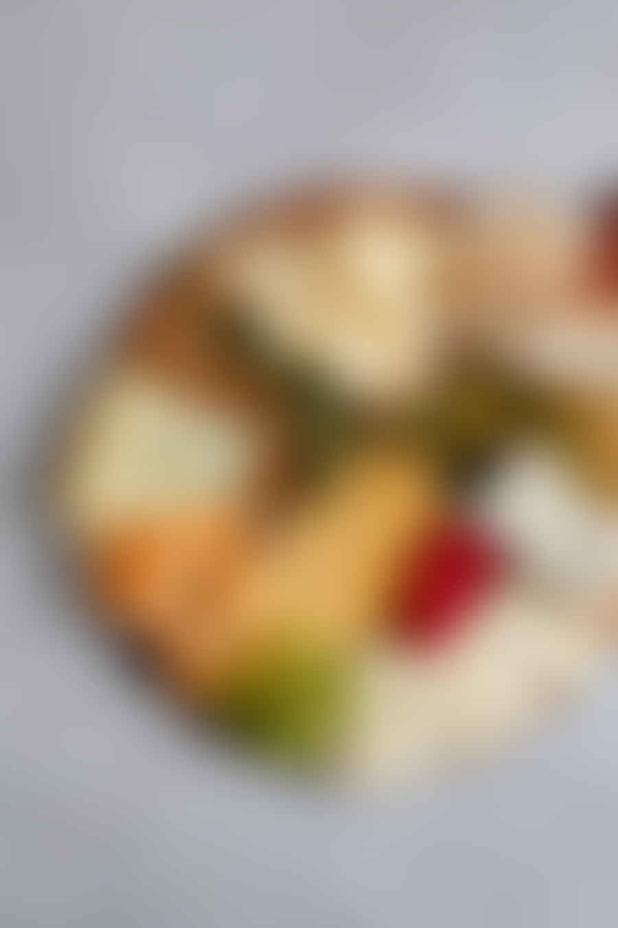 A beautifully arranged charcuterie board with diverse cheese types, cured meats, fruits, and crackers